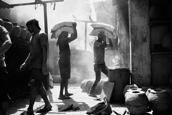 February 2023, Mumbai, India: Men bringing raw materials to Kumbharwada (Pottery village), Dharavi