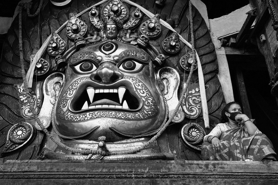 A woman sitting by the Swet Bhairab statue that has been opened for worship during the Indra Jatra festival in Kathmandu