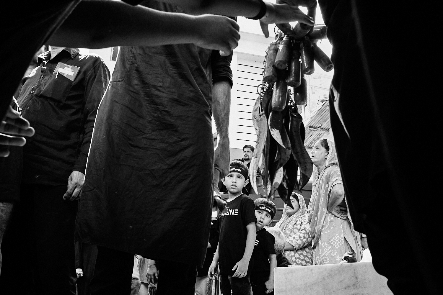 Young kids look as sharp objects are distributed during Ashura observance. Ahmedabad, India. 2023