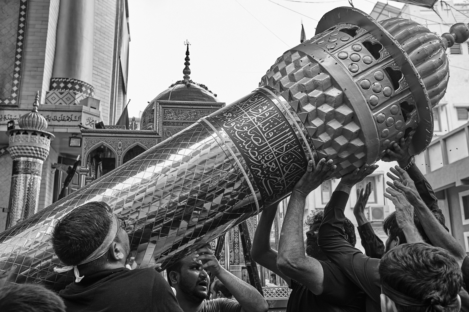 People handling one of the minarets of a tazia. Ahmedabad, India. 2024
